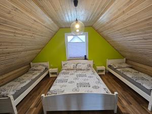 Duas camas num quarto com uma parede verde em Magiczny Zakątek Bałtów em Bałtów