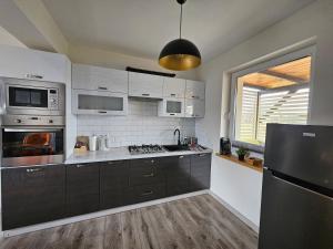 uma cozinha com electrodomésticos de aço inoxidável e um frigorífico preto em Magiczny Zakątek Bałtów em Bałtów