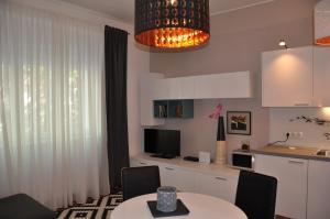 a living room with a table and a kitchen at Apartments Sulekova in Zagreb