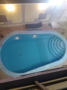 a large blue tub in a room with chairs at Hoppa Guest House Nile View in Luxor