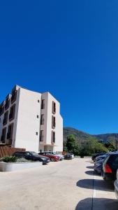 a building with cars parked in a parking lot at Tivat lovely cosy studio in Tivat