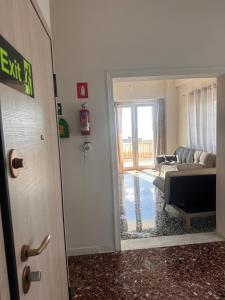 a door to a living room with a couch at Agioi Theodoroi Beachview Chic Modern Apt in Agioi Theodoroi