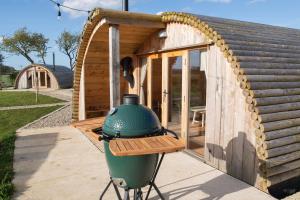 a small wooden house with a green pot on a grill at Glamping Pod 3 Harmony in Scarborough +3 photos