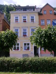 a large white building with windows on a street at Hotel an der Fähre in Sankt Goar