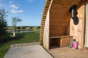 a wooden outhouse with a bench and a window at Glamping Pod 5 Shelter in Scarborough