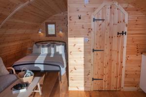 a bedroom with a bed in a wooden cabin at Glamping Pod 5 Shelter in Scarborough