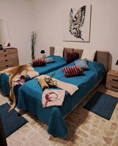 2 Betten mit blauer Bettwäsche in einem Zimmer mit Schmetterling in der Unterkunft The Palm Villa in St Paul's Bay