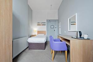 a hotel room with a bed and a desk with a purple chair at Royal Whitby in Whitby +56 photos