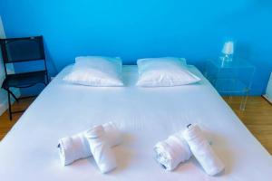 a white bed with three white towels on it at Splendide appartement de 75m2 avec place de parking à Biarritz tout inclus in Biarritz