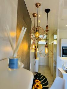 a kitchen with three chandeliers and a table at Costa Adeje Orlando Tenerife Sea View - Pool - AC in Adeje +51 photos