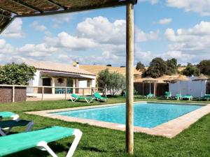 a pool with chairs and a house at 7 bedrooms villa with private pool enclosed garden and wifi at Prado del Rey in Prado del Rey