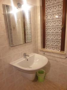 Agriturismo La Scalera في لوناتو: حمام مع حوض أبيض ومرآة
