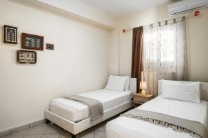 two beds in a room with a window at Villa Nina with Private Plunge Pool, 5km to Corfu Town in Corfu Town +17 photos