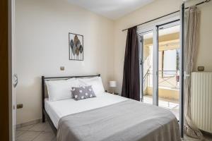 a bedroom with a bed and a sliding glass door at Villa Nina with Private Plunge Pool, 5km to Corfu Town in Corfu Town