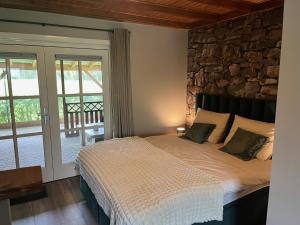 a bedroom with a bed with a stone wall at B&B Hoeve Fraai Achterhoek in Aalten