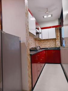 kuchnia z czerwono-białymi szafkami w pokoju w obiekcie Family 3bhk Home stay! w Nowym Delhi