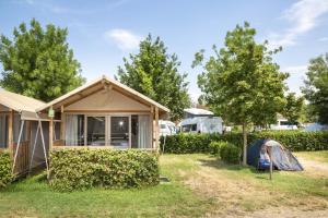 ein Haus mit einem Zelt und Bäumen im Hof in der Unterkunft hu Venezia Camping in Town in Marghera