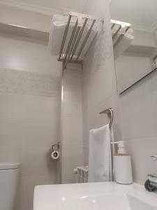 a white bathroom with a sink and a mirror at La Campanilla-Suances in Suances