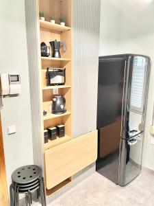 a kitchen with a black refrigerator in a room at Estudio Regenta Con Parking privado in Oviedo