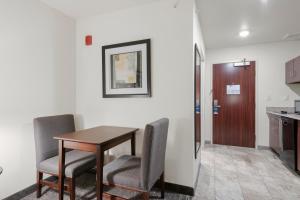 a room with a table and chairs and a kitchen at Cobblestone Hotel & Suites - Russells Point at Indian Lake in Russells Point