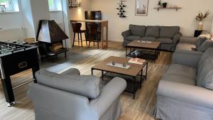 a living room with couches and tables and a piano at Ellernhof in Dahlenburg