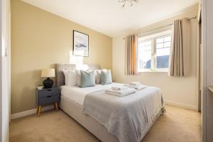 a bedroom with a large white bed with a window at The Morden Collection in London