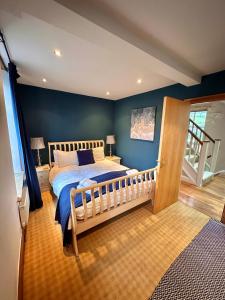 a bedroom with a bed and a blue wall at Clare's Cottage Near Cartmel - Dog Friendly, Homely, Aga, Log Burners, Disney Plus & Netflix in Holker