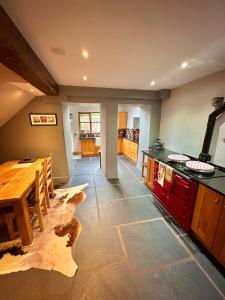 a kitchen with a wooden table and a dining room at Clare's Cottage Near Cartmel - Dog Friendly, Homely, Aga, Log Burners, Disney Plus & Netflix in Holker