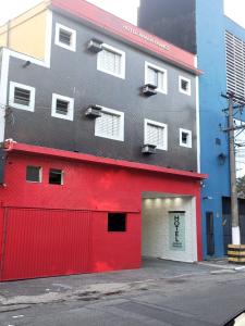 a red and gray building with a garage at Hotel Anália Franco in Sao Paulo