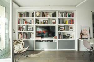 uma sala de estar com uma grande prateleira de livros brancos em 16th District Spacious Sophistication em Montreuil