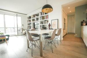 uma sala de jantar com uma mesa branca e cadeiras em 16th District Spacious Sophistication em Montreuil