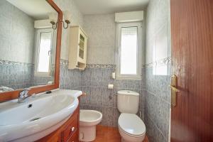 a bathroom with a sink and a toilet and a mirror at Casa Margarita, al lado de Laredo in Rada +11 photos