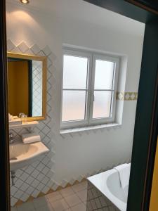 a bathroom with a sink and a mirror at Hotel Grünwaldkopf in Obertauern