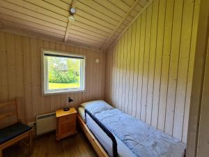 a small bedroom with a bed and a window at Ferienhaus-Buche in Presen