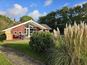 a red and white house with a patio at Ferienhaus-Buche in Presen