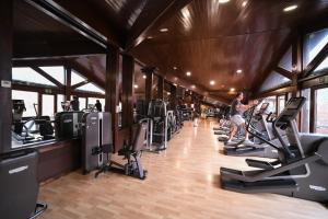 a woman walking through a gym with cardio equipment at Aparthotel AnyosPark Mountain & Wellness Resort in Anyós