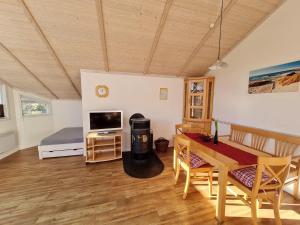 a living room with a dining table and a bedroom at Ferienhaus-Linde in Presen