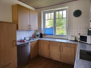a kitchen with wooden cabinets and a sink and a window at Doppelhaushaelfte-Kornblume in Presen