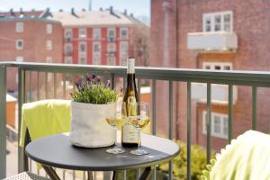 a table with two glasses of wine on a balcony at The Apartments Company - Majorstuen in Oslo