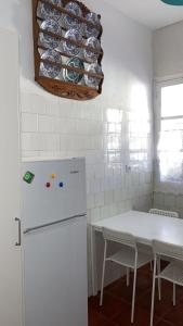 a kitchen with a white refrigerator and a table with chairs at APCH5 Marga in Chinchón