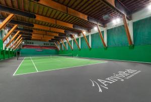an indoor tennis court with a tennis racket on the court at Aparthotel AnyosPark Mountain & Wellness Resort in Anyós