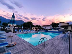 una gran piscina con sillas y sombrilla en Camping Italia'90 Apartment two levels, en Domaso