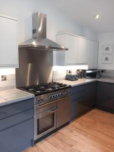 a kitchen with a stainless steel stove top oven at Chapter Farm Cottages in Canterbury