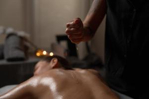 a man laying on a bed getting a hair cut at Aparthotel AnyosPark Mountain & Wellness Resort in Anyós