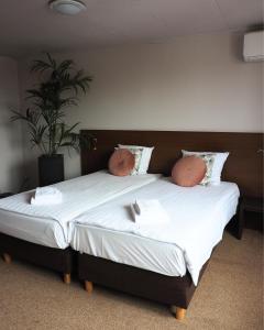 a large bed with two pillows on top of it at Hotel 't Vertrek in Boxmeer