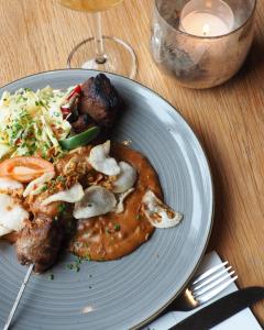 ein Teller mit Fleisch und Gemüse auf dem Tisch in der Unterkunft Hotel 't Vertrek in Boxmeer