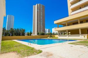 - une piscine en face d'un bâtiment avec de grands bâtiments dans l'établissement Sweet Home Casa dos Arcos 409, à Portimão