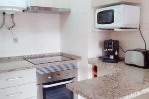 Il comprend une cuisine équipée d'une cuisinière et d'un four micro-ondes. dans l'établissement Sweet Home Casa dos Arcos 409, à Portimão