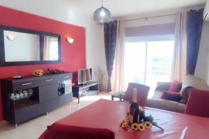 - un salon avec un mur rouge, un canapé et une table dans l'établissement Sweet Home Casa dos Arcos 409, à Portimão