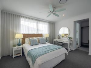 1 dormitorio con 1 cama y ventilador de techo en Stunning Luxurious 4 Bedroom Mansion Rochedale, en Rochedale